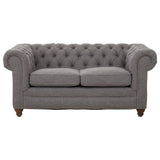 Two-seat sofa upholstered in grey linen with a tufted backrest and rolled arms, featuring wooden legs. The cushions are plush and inviting, designed for comfort and style