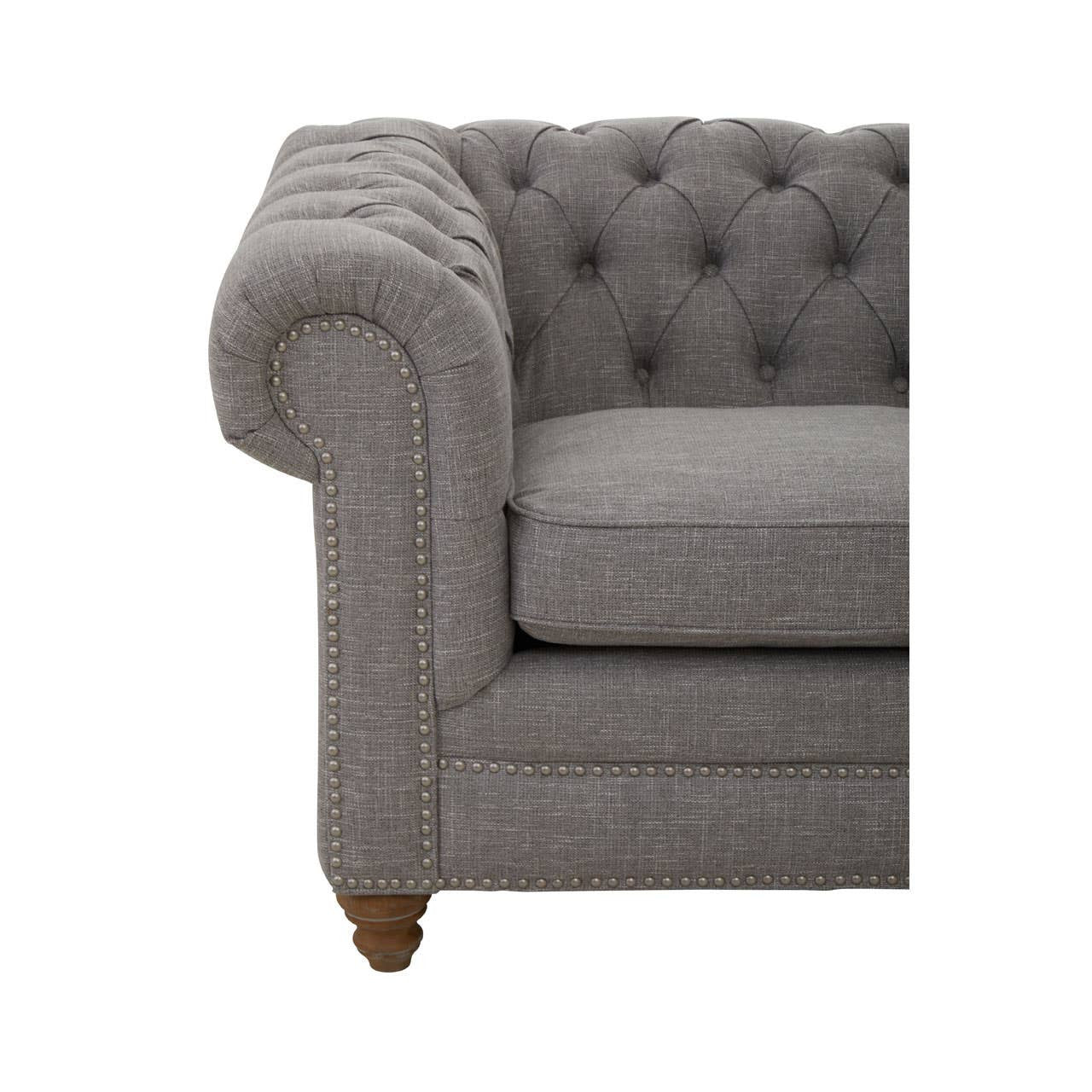 Grey linen sofa featuring a tufted backrest and rolled armrest, supported by wooden legs. The upholstery has a soft texture, and the overall design is elegant and contemporary