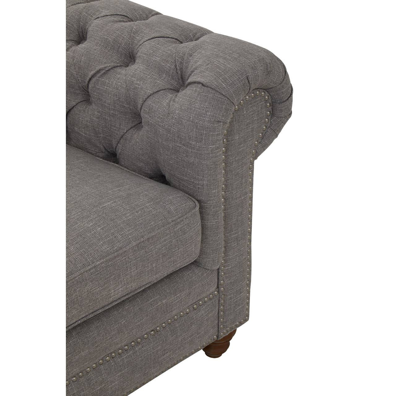 Grey linen sofa with a tufted design on the armrest and backrest, featuring a low-profile silhouette and wooden legs. The fabric has a soft texture, and the overall style is modern and elegant, suitable for home decor