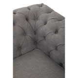 Close-up view of the corner of a two-seat sofa upholstered in grey linen, featuring tufted detailing on the backrest and seat. The fabric has a soft texture, and the overall design appears modern and stylish