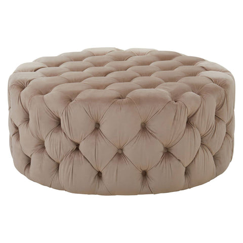 Beige velvet round ottoman stool with tufted detailing, featuring a soft, plush surface and a circular shape, suitable for use as a footrest or additional seating