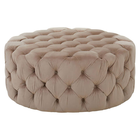 Beige velvet round ottoman stool with tufted detailing, featuring a soft, plush surface and a circular shape, suitable for use as a footrest or additional seating