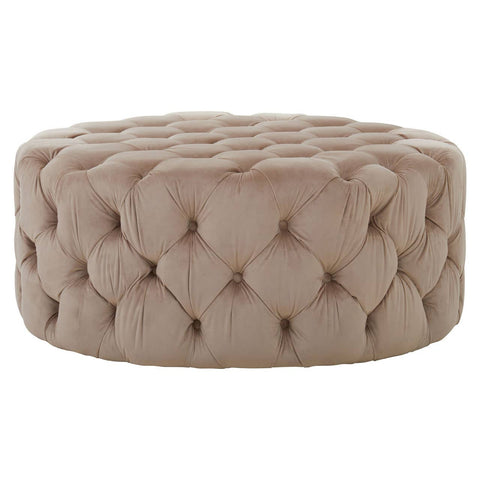Beige velvet round ottoman stool with a tufted design, featuring a soft, plush surface and a circular shape, suitable for use as a footrest or additional seating