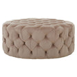 Beige velvet round ottoman stool with a tufted design, featuring a soft, plush surface and a circular shape, suitable for use as a footrest or additional seating