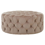 Beige velvet round ottoman stool with a tufted design, featuring a soft, plush surface and a circular shape, suitable for use as a footrest or additional seating