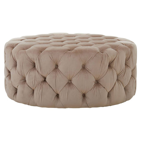 Beige velvet round ottoman stool with a tufted design, featuring a soft, plush surface and a circular shape, suitable for use as a footrest or additional seating