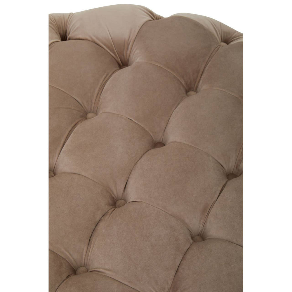 Beige velvet round ottoman stool with a tufted design, featuring soft, rounded edges and a plush surface. The fabric has a smooth texture, and the stitching is visible, adding to its elegant appearance