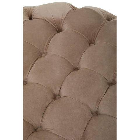 Beige velvet round ottoman stool with a tufted design, featuring soft, rounded edges and a plush surface. The fabric has a smooth texture, and the stitching is visible, adding to its elegant appearance