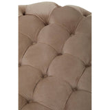 Beige velvet round ottoman stool with a tufted design, featuring soft, rounded edges and a plush surface. The fabric has a smooth texture, and the stitching is visible, adding to its elegant appearance