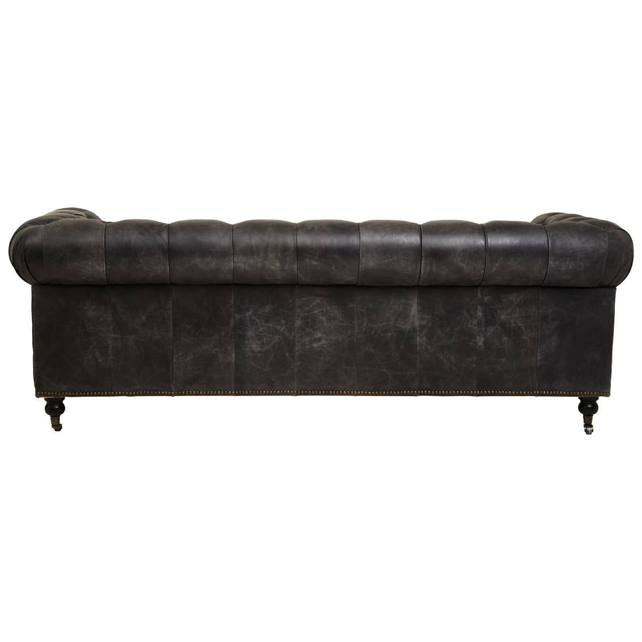 Antique black Chesterfield leather sofa featuring a classic tufted backrest and rolled arms, supported by elegant wooden legs. The sofa is designed for three seats, showcasing a vintage aesthetic with a rich texture