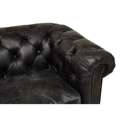 Antique black leather Chesterfield sofa featuring a tufted design on the armrest and back, showcasing a classic and elegant style. The leather has a distressed finish, adding character to the piece