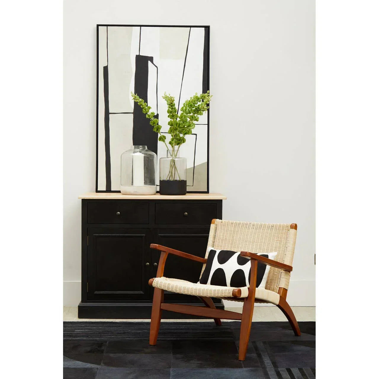 Modern wooden accent chair with woven seat and black cabinet in contemporary living room