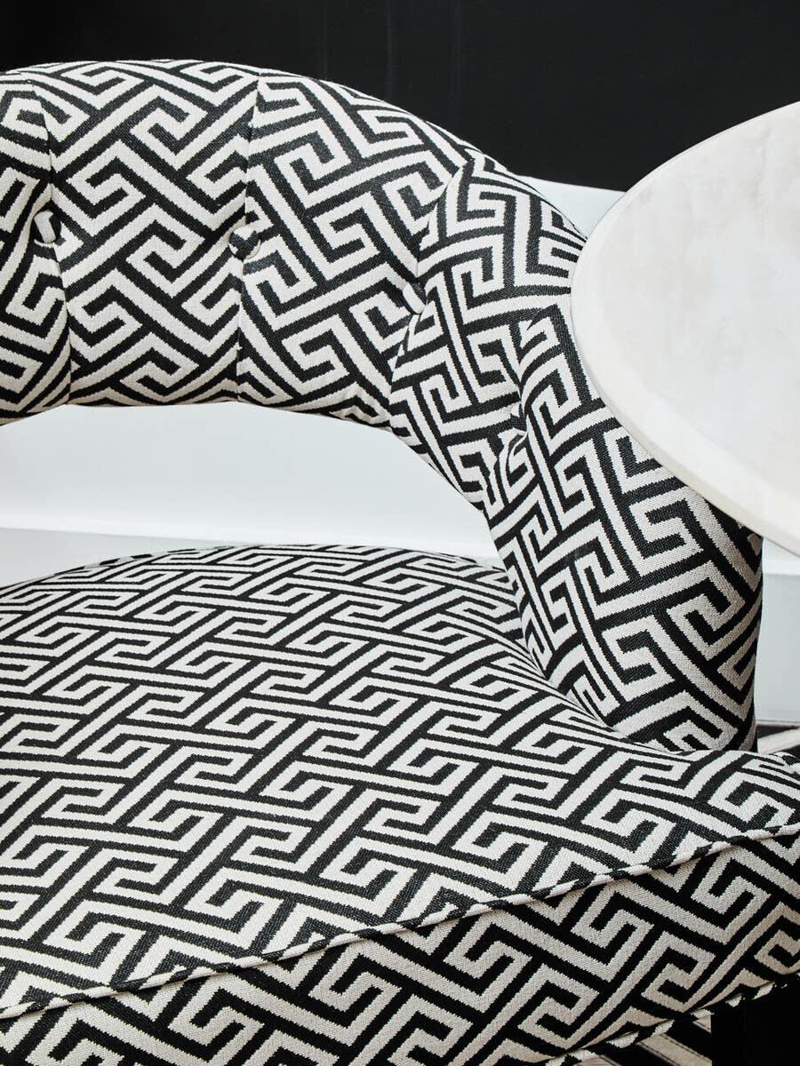 Black and white geometric patterned dining chair with curved backrest and cushioned seat