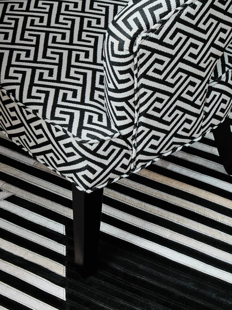 Patterned accent chair with black and white geometric upholstery and black wooden legs