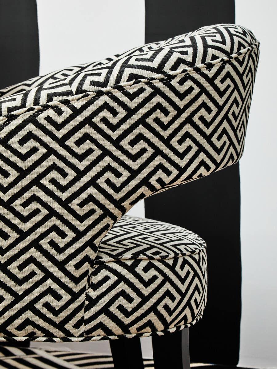 Black and white geometric patterned accent chair with curved backrest and dark wooden legs
