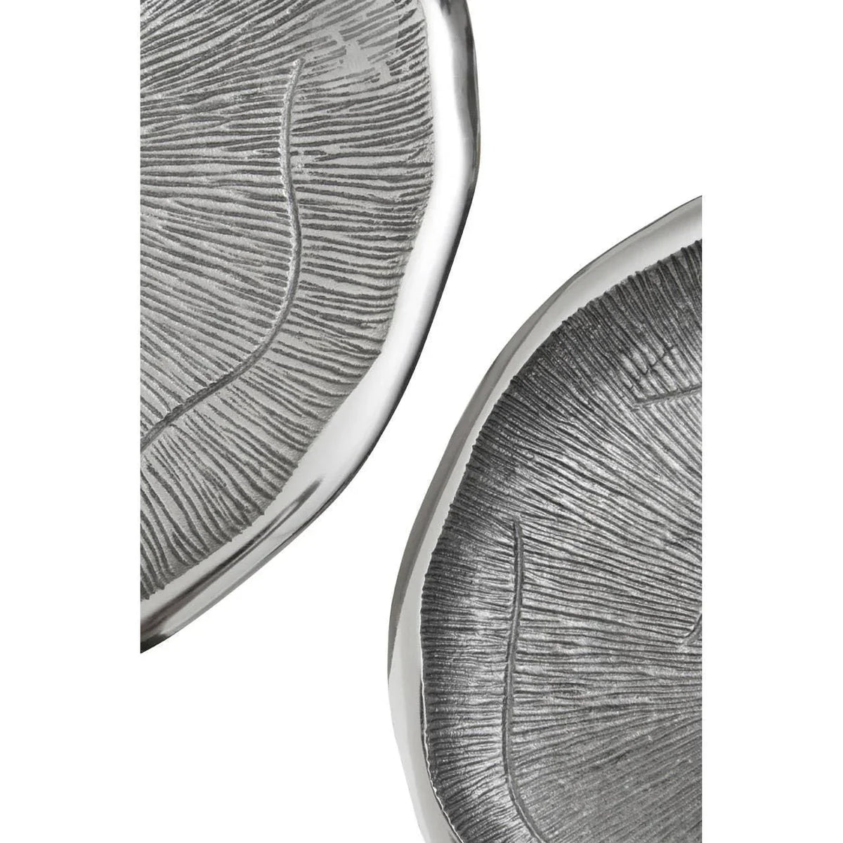 Close up of two textured silver decorative trays with leaf pattern detail