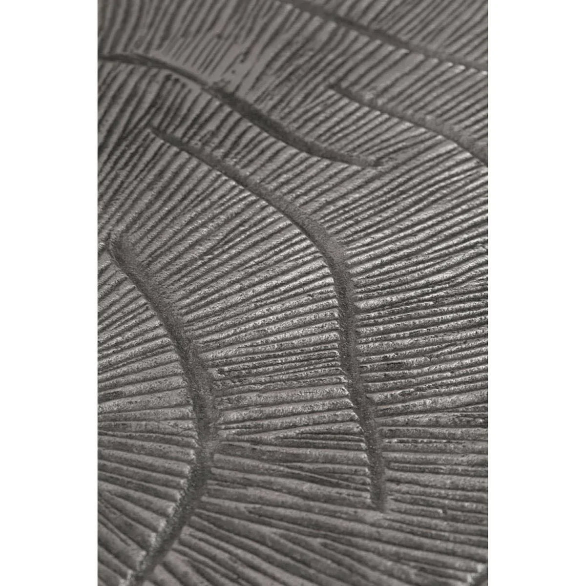 Textured metal table surface with embossed leaf pattern detail