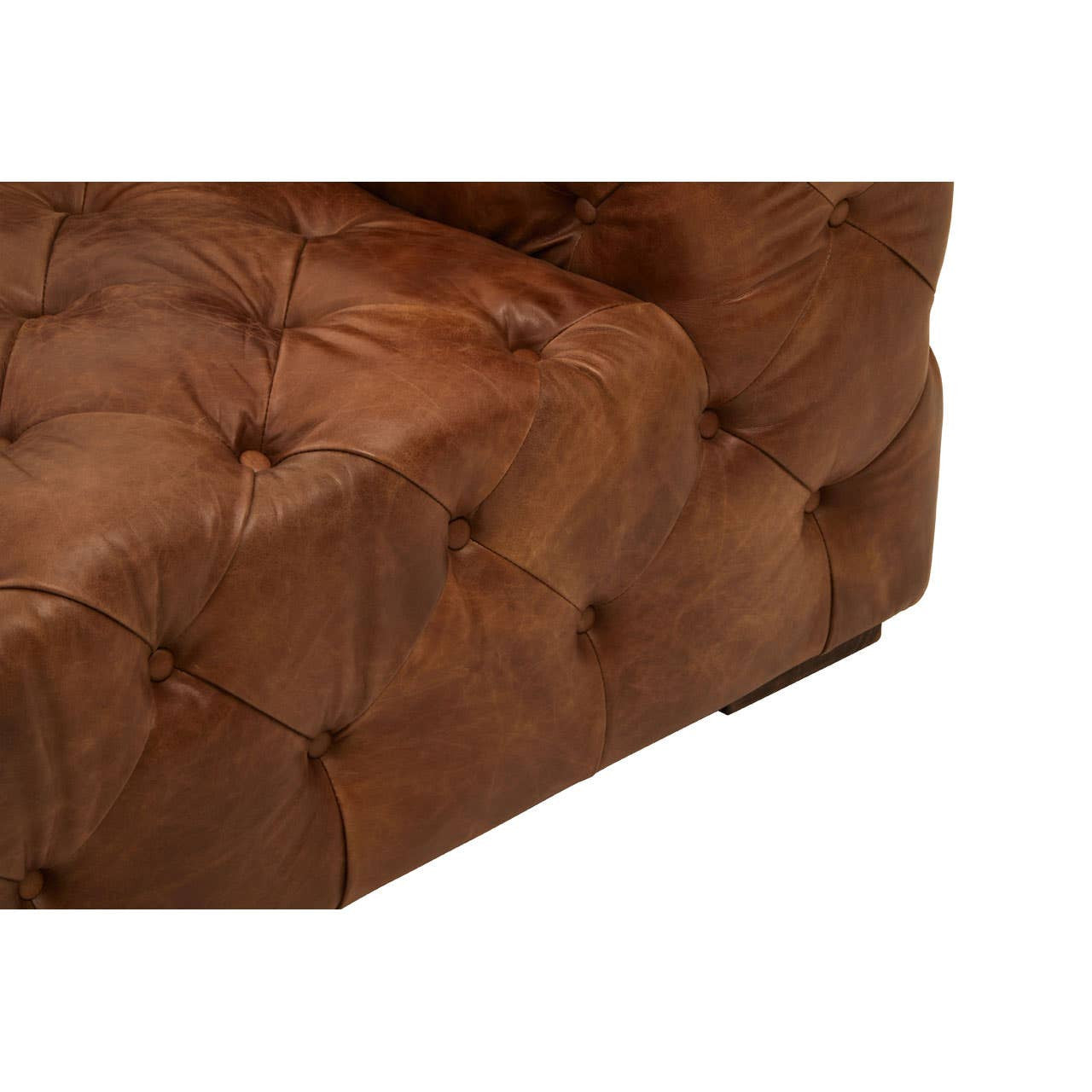 Brown leather corner of a modern Chesterfield modular sofa featuring tufted detailing and a sleek design. The rich color and texture highlight the luxurious appearance of the material