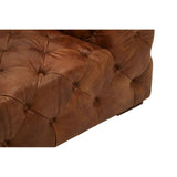 Brown leather corner of a modern Chesterfield modular sofa featuring tufted detailing and a sleek design. The rich color and texture highlight the luxurious appearance of the material