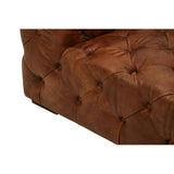 Brown leather upholstery with a tufted design, showcasing the corner and arm of a modern Chesterfield sofa. The texture of the leather is visible, highlighting its rich color and craftsmanship