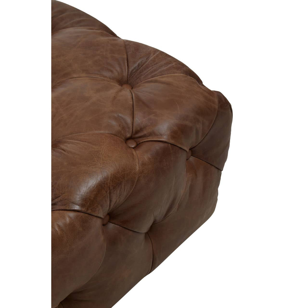 Close-up view of a brown leather modular sofa chair featuring a tufted design, showcasing the texture and stitching of the leather upholstery. The corner of the chair is visible, highlighting its modern Chesterfield style