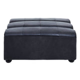 Antique black leather modular ottoman with a tufted top and rounded edges, featuring a sturdy base and small, round feet
