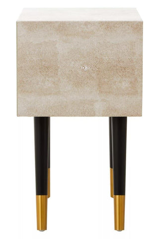 Textured beige bedside table with black legs and gold tips, front view