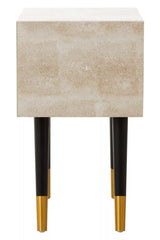 Textured beige bedside table with black legs and gold tips, front view
