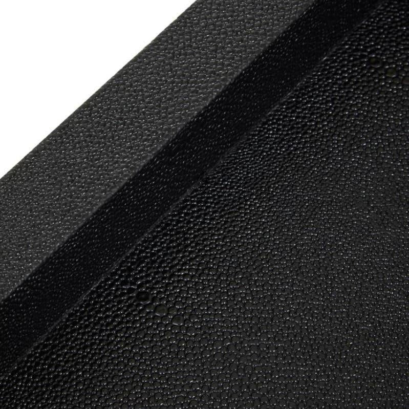 Close-up of black textured serving tray corner, showing raised edge and matte finish