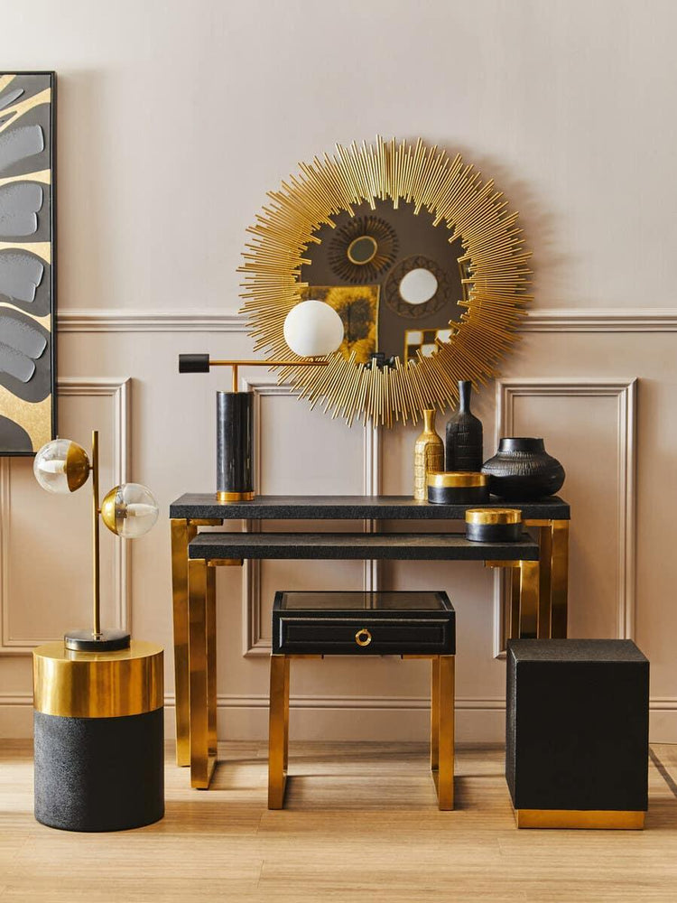 Black and gold console table set with sunburst mirror and decorative vases in modern hallway