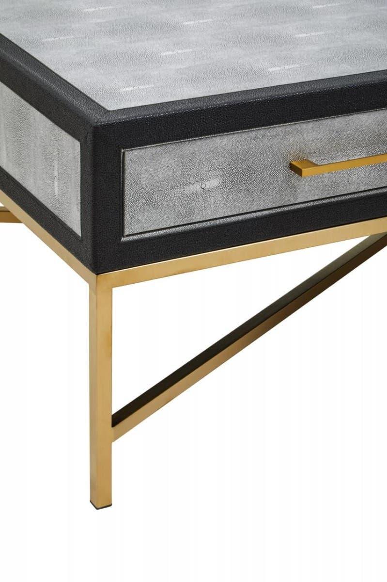 Modern coffee table with textured grey drawer, gold metal legs and geometric frame