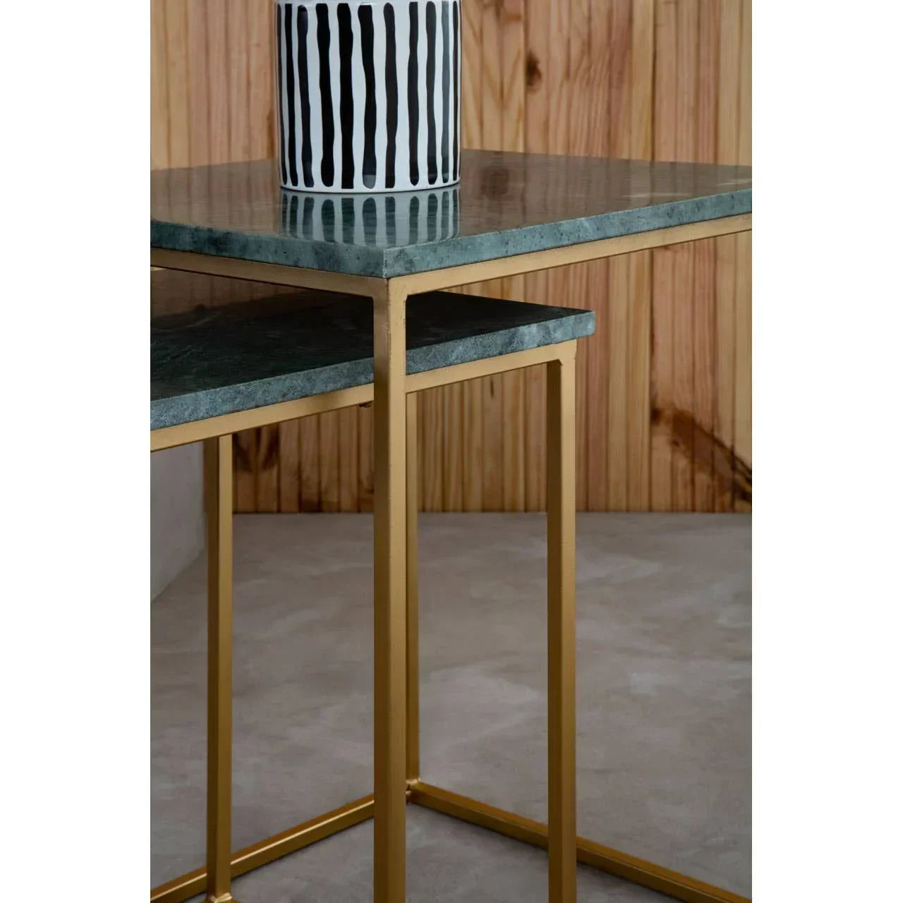 Green marble nesting tables with gold metal frames and a black and white striped vase