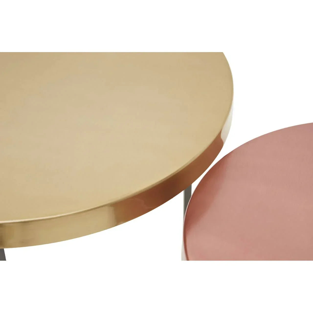 Round gold metal side table beside pink upholstered stool, close-up view