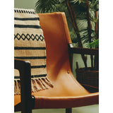 Tan leather accent chair with wooden arms and woven throw blanket in living room setting