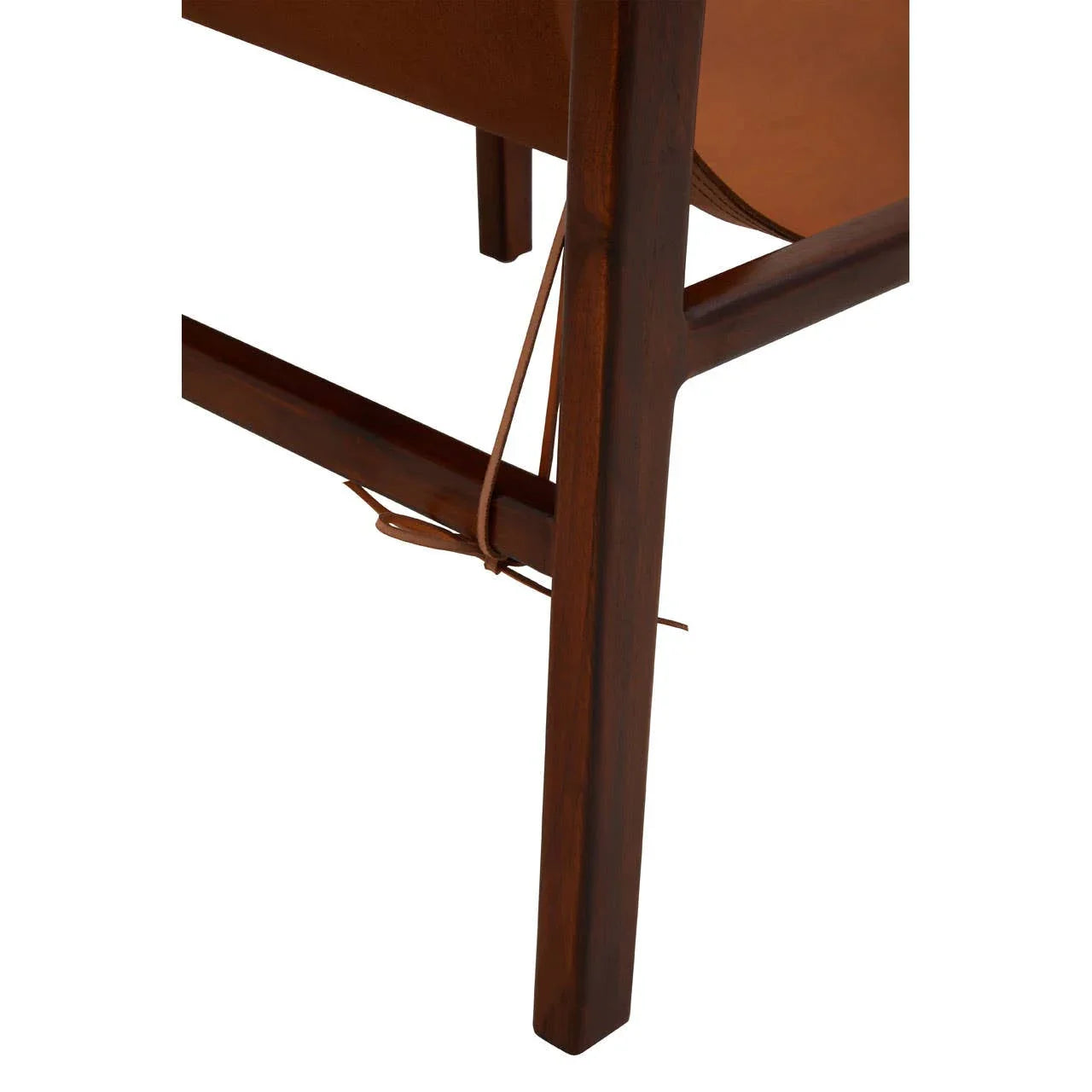 Close-up of wooden chair leg with brown leather seat and tie detail