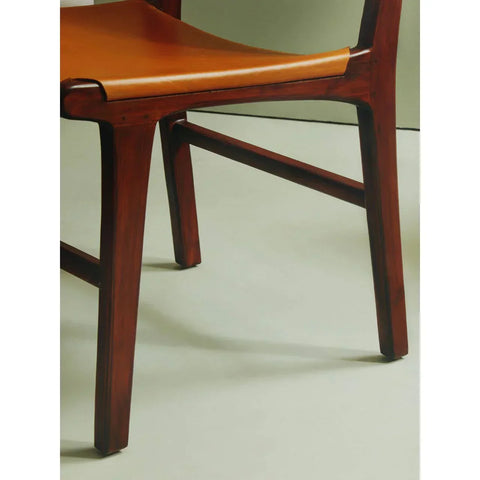Walnut wood dining chair with tan leather seat, angled view of legs and seat base