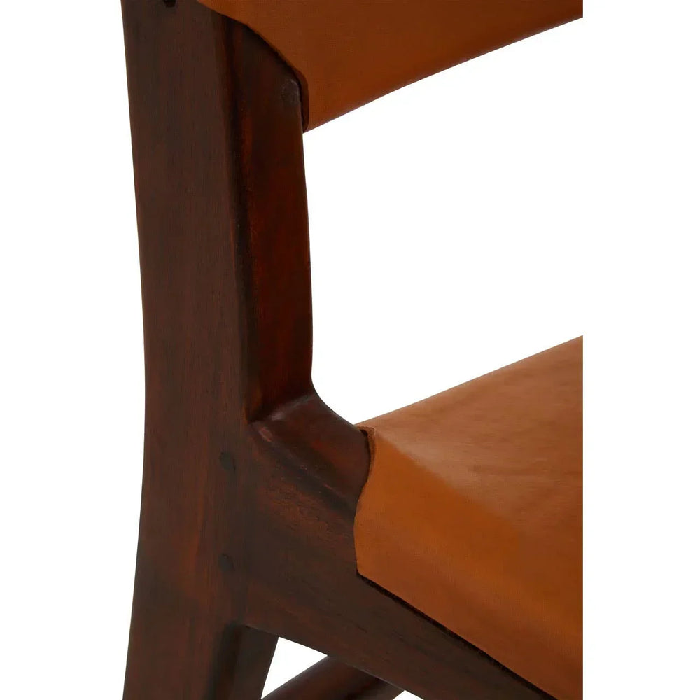 Close up of wooden dining chair frame with brown leather seat and backrest