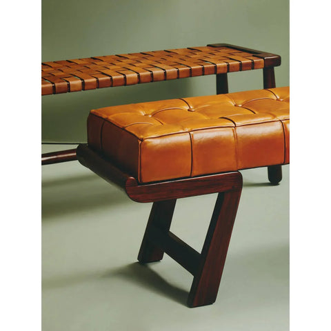 Tan leather bench with tufted cushion and dark wood frame, side angle view