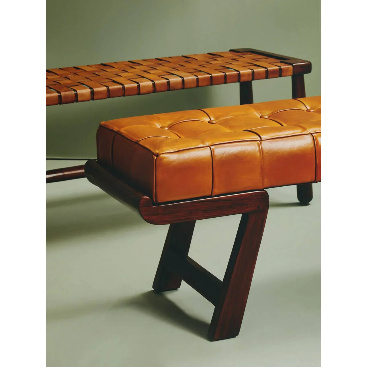 Tan leather bench with tufted cushion and dark wood frame, side angle view