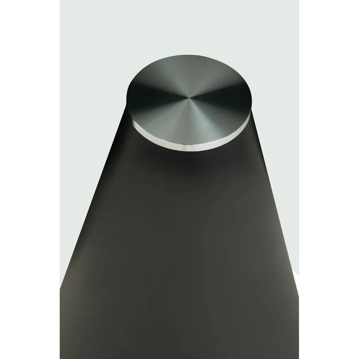 Brushed metal table leg with circular top and matte black finish, angled overhead view
