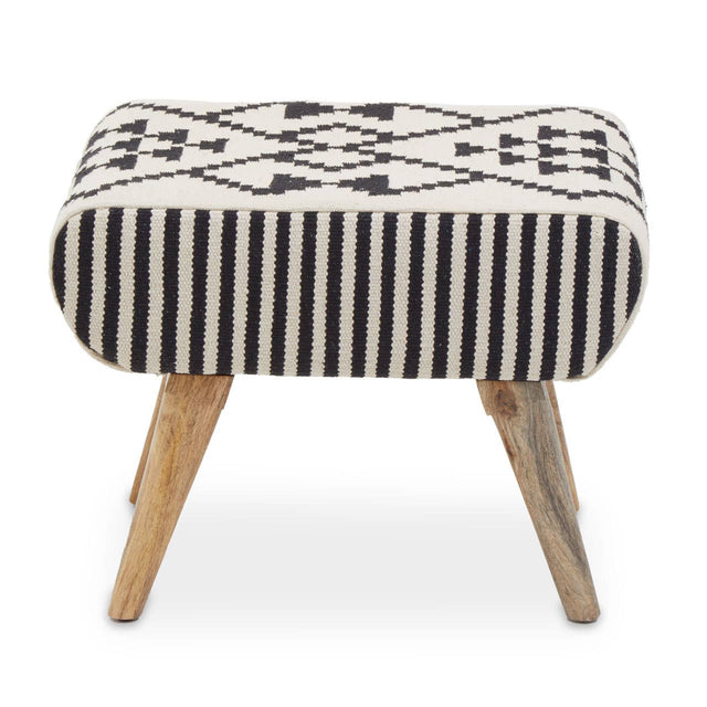 A footstool with a rounded top featuring a black and white geometric pattern, supported by four wooden legs. The design combines striped and patterned fabric, giving it a modern yet cozy look suitable for home decor
