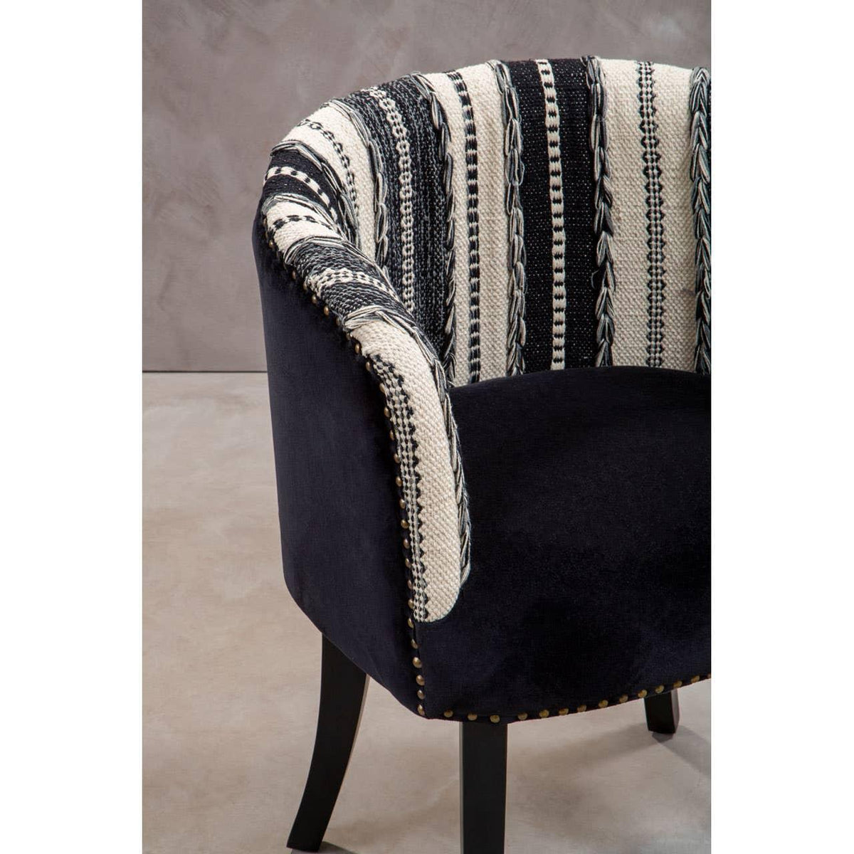 Black accent chair with patterned cream and black fabric upholstery and studded trim
