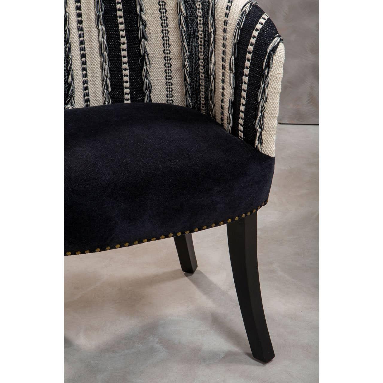 Upholstered accent chair with black velvet seat, patterned fabric backrest, and wooden legs