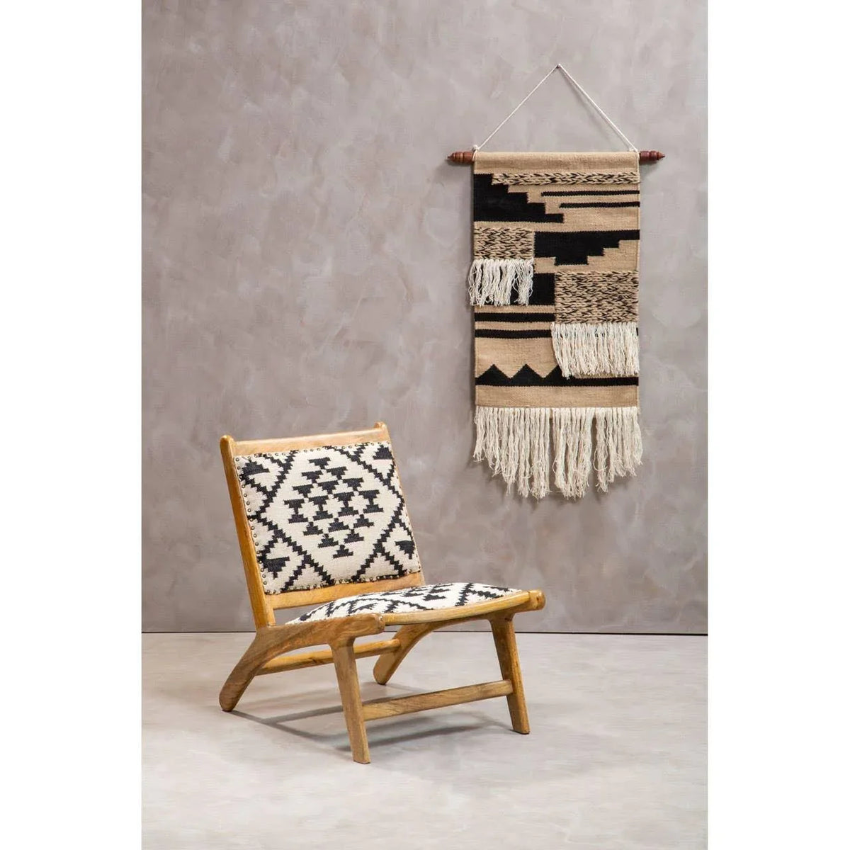Wooden accent chair with geometric woven upholstery beside boho wall hanging