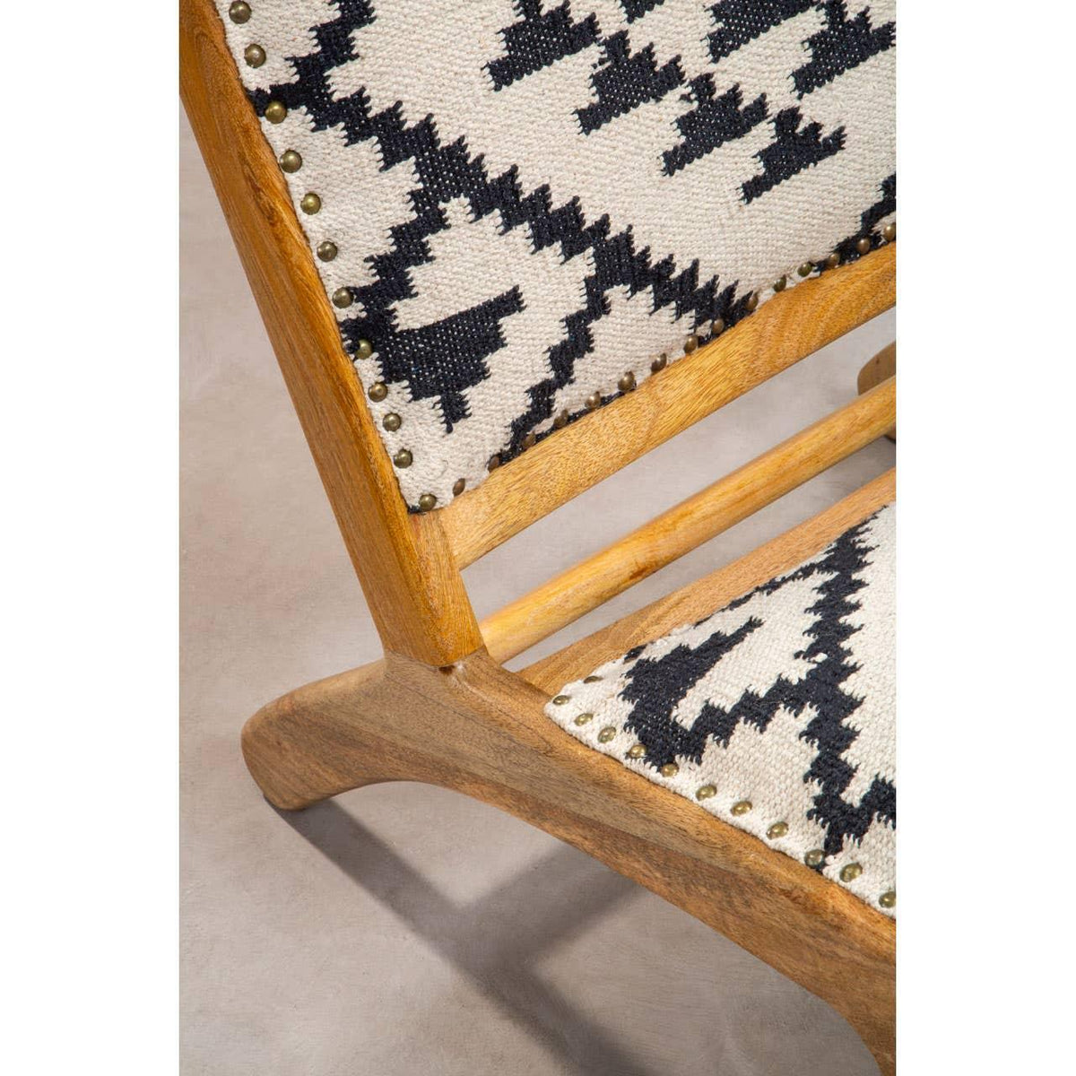 Close up of wooden chair frame with black and white geometric patterned upholstered seat