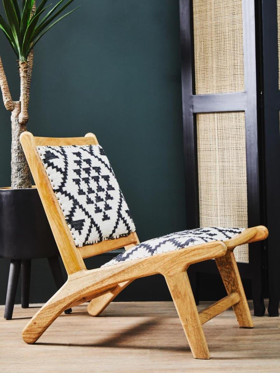 Wooden lounge chair with black and white patterned upholstery in modern living room setting