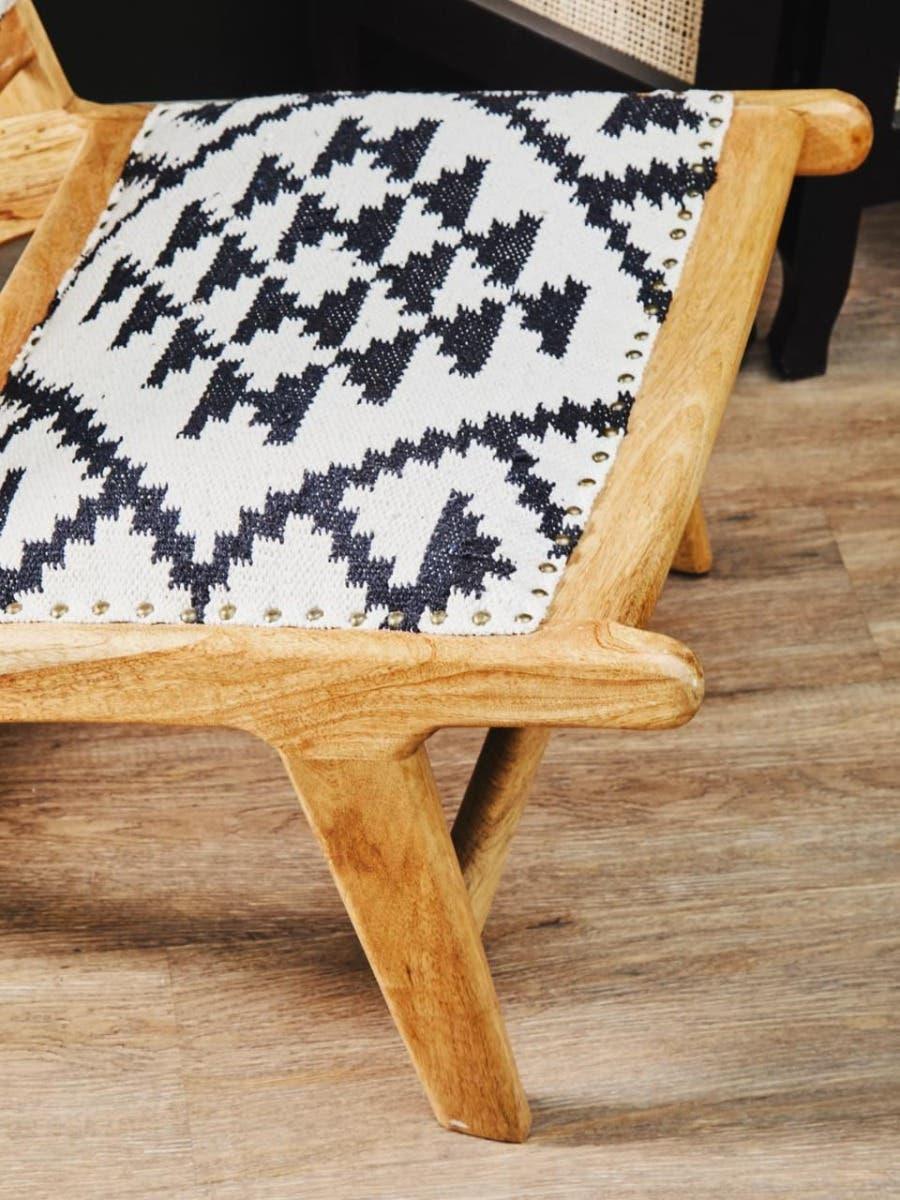 Wooden bench with black and white geometric fabric seat on wooden floor
