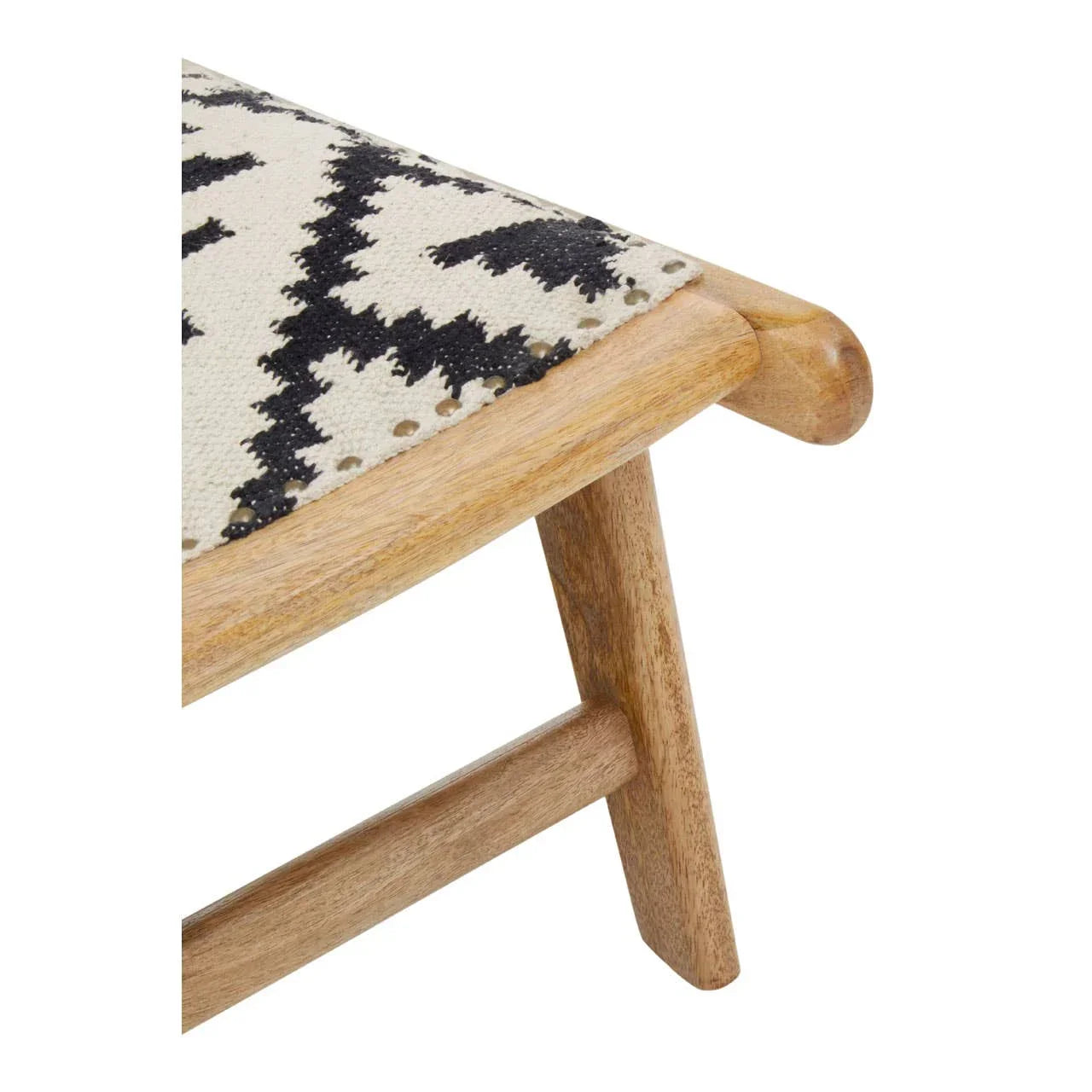 Close-up of wooden bench leg with black and white patterned fabric seat