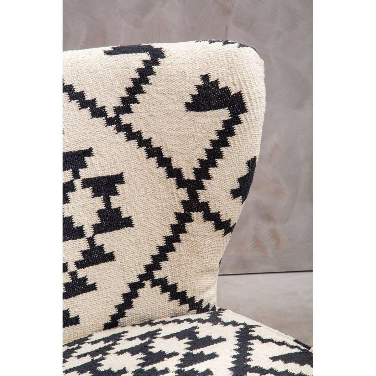 Accent chair with cream and black geometric upholstery and textured fabric close-up