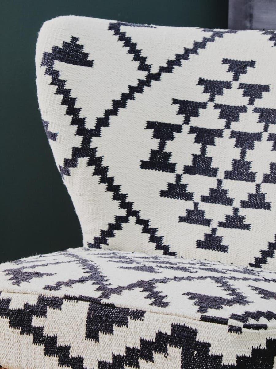Black and white accent chair with geometric patterned upholstery, close up of seat and back